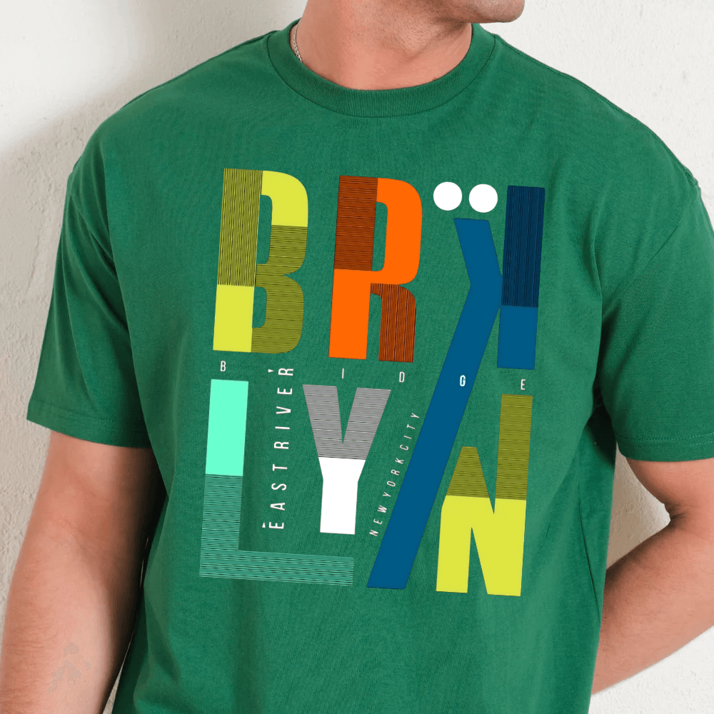 Green t-shirt with colorful text design worn by a person against a neutral background