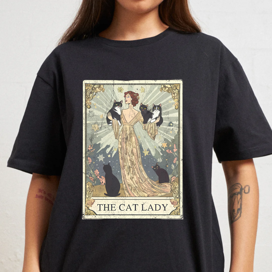 Black t-shirt with 'The Cat Lady' graphic design featuring a woman holding cats on a white background.