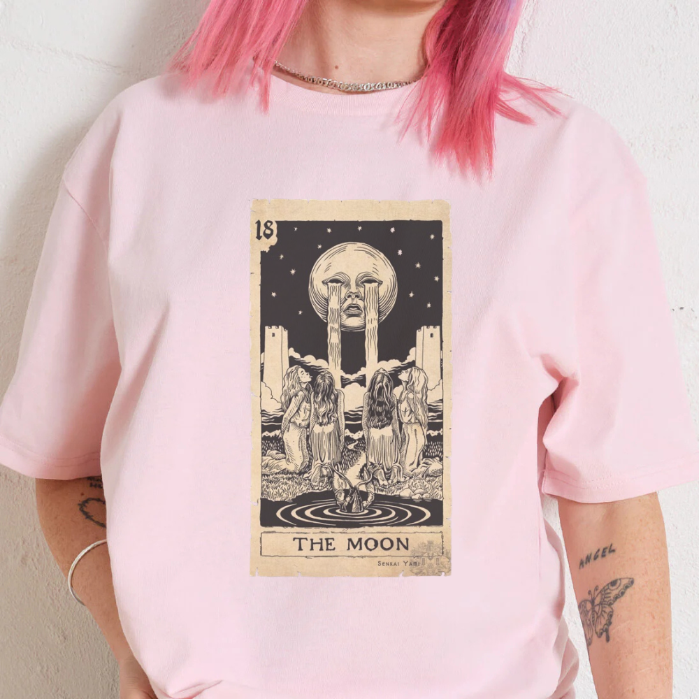 Graphic tee featuring 'The Moon' tarot card design on a pink oversized shirt, showcasing a unique 90s-inspired style.