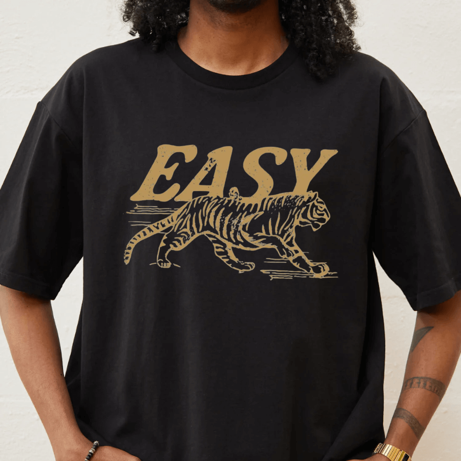 Person wearing a black t-shirt with a gold tiger graphic and 'EASY' text.