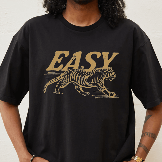 Person wearing a black t-shirt with a gold tiger graphic and 'EASY' text.