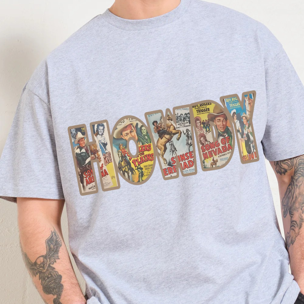 Gray t-shirt with 'Howdy' design featuring vintage movie poster art, worn by a person.