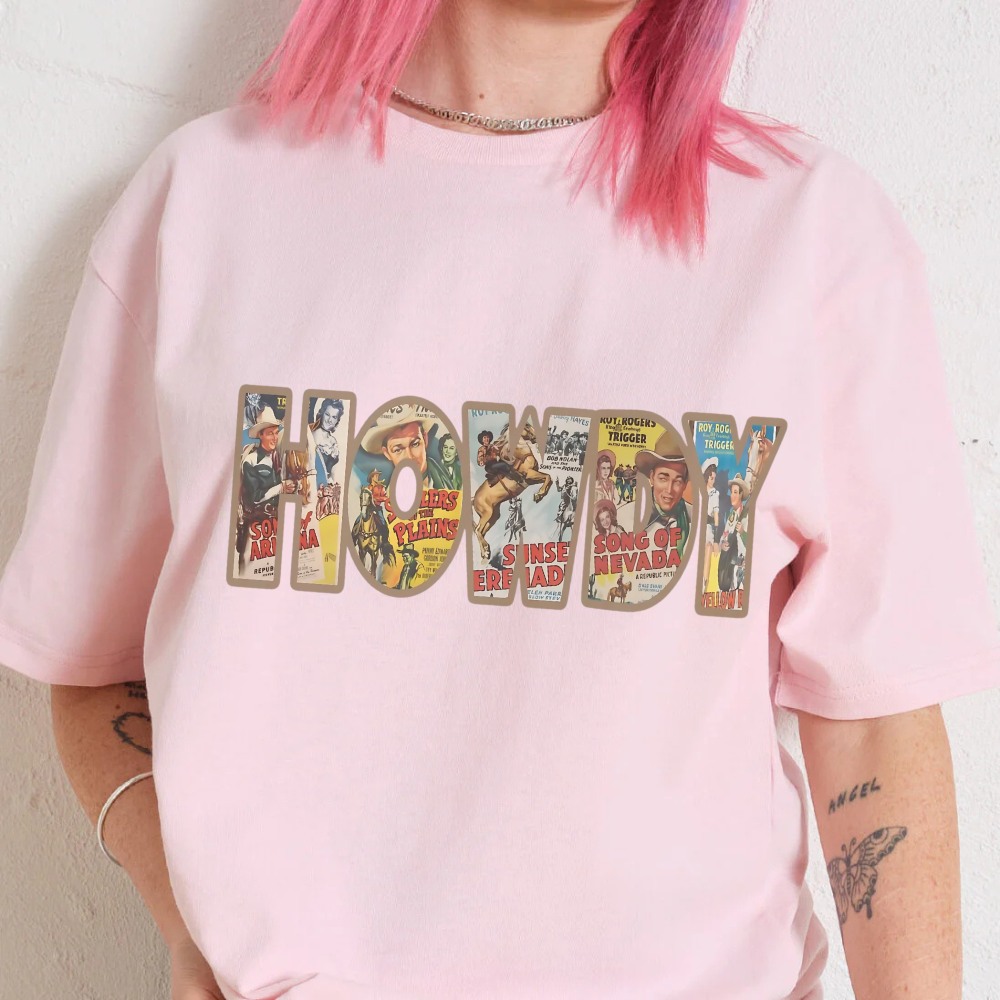 Person wearing a pink t-shirt with 'HOWDY' text and comic book character illustrations.