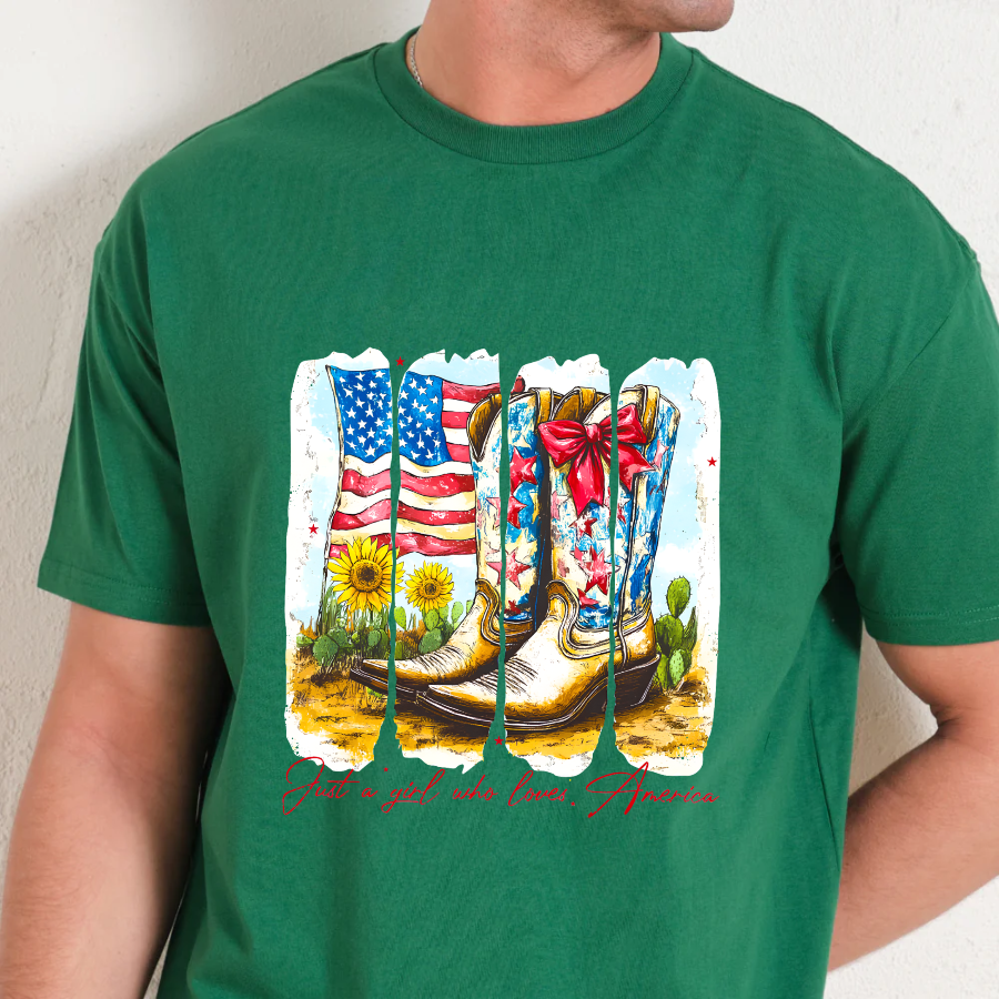 Green t-shirt with a graphic of boots, an American flag, flowers, and cacti on a plain background.
