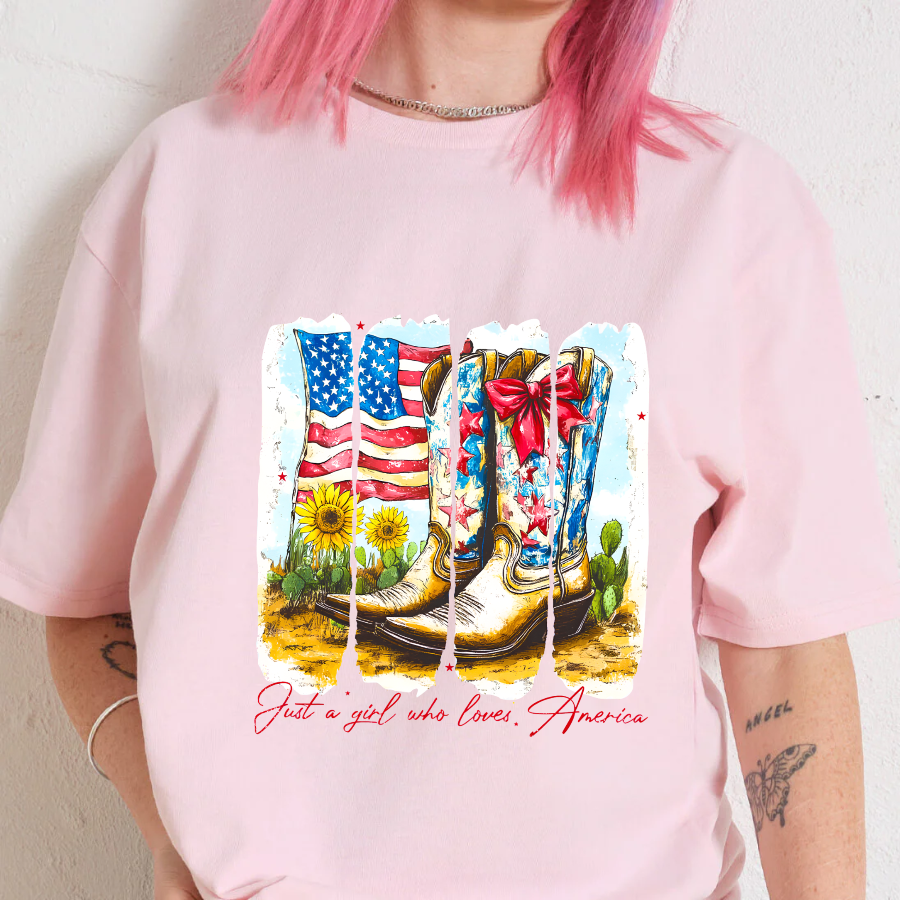 Person wearing a pink t-shirt with a graphic design of boots, an American flag, and cacti.