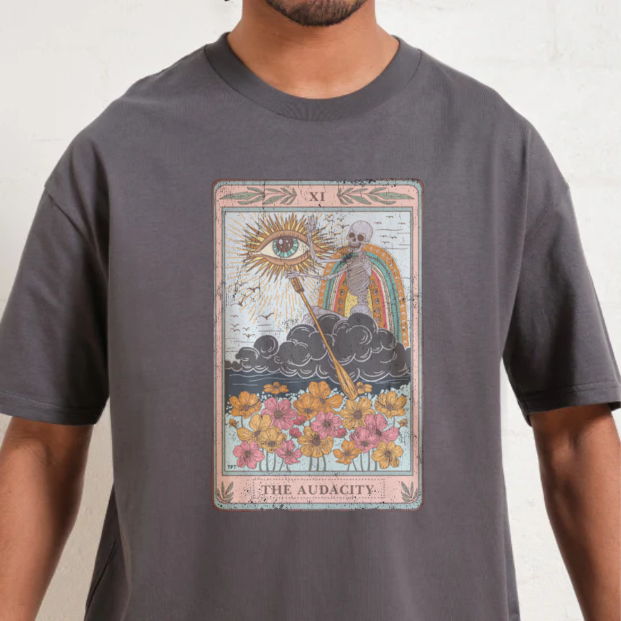 Person wearing a gray t-shirt with a tarot card design on a plain background