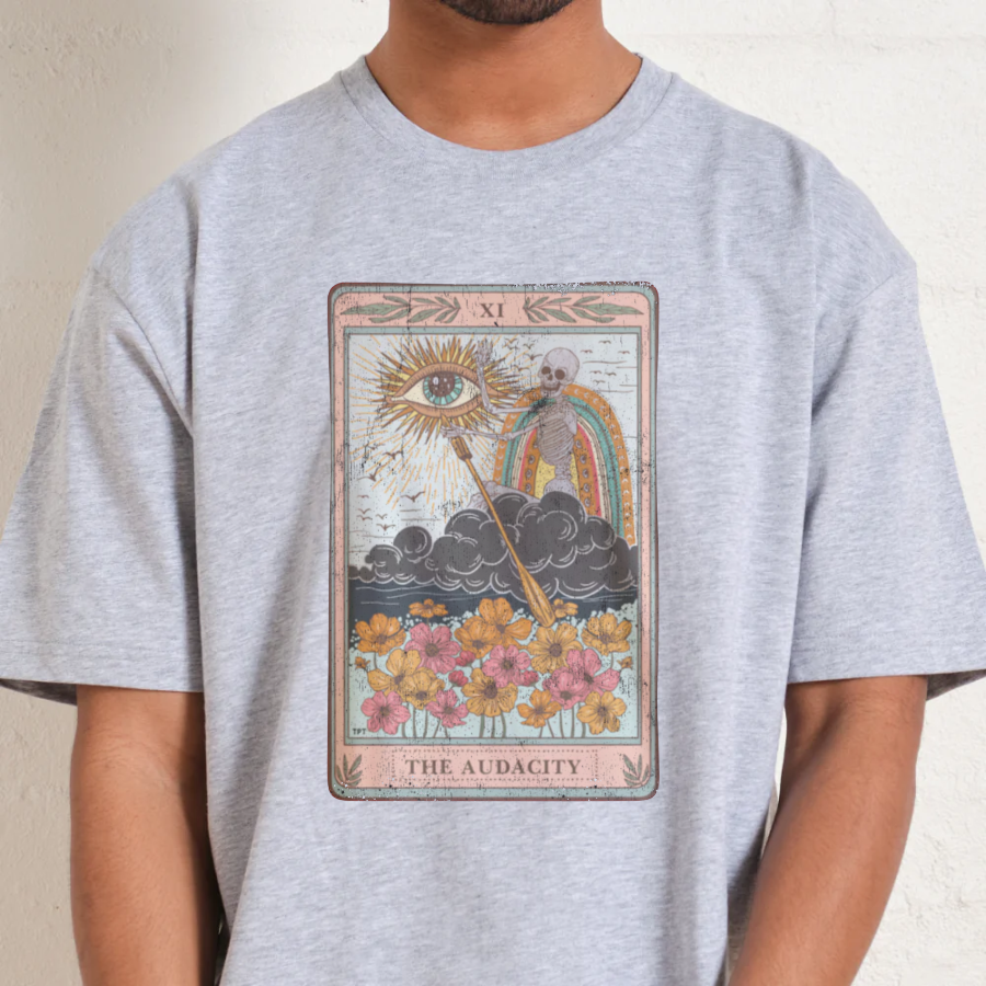 Person wearing a gray t-shirt with a tarot card design on a plain background