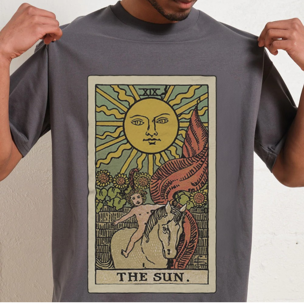 Person wearing a gray t-shirt with 'The Sun' tarot card design.