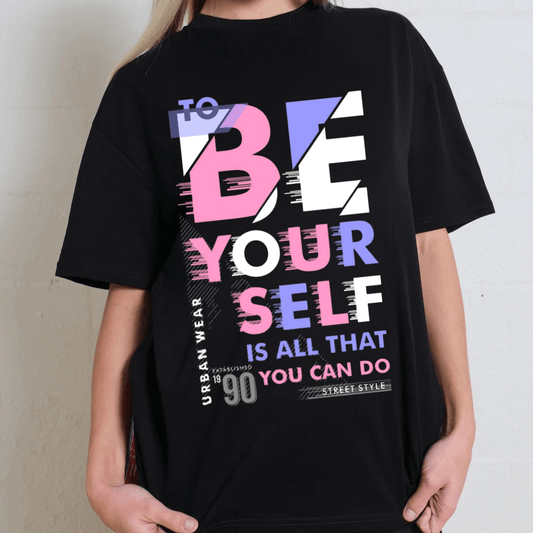 Black oversized graphic tee featuring 'To Be Yourself' slogan in vibrant typography. Unisex 90s-inspired street style fashion.