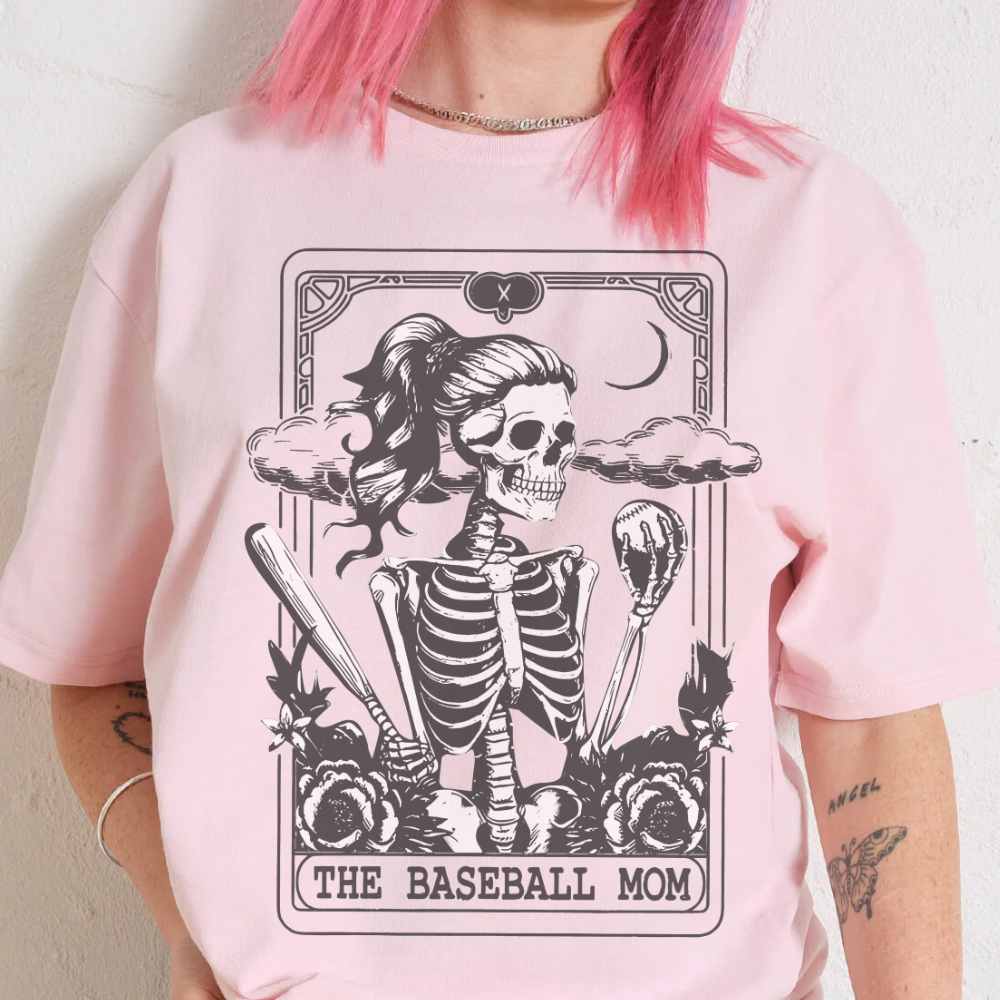 Person wearing a pink t-shirt with a skeleton design and 'The Baseball Mom' text.