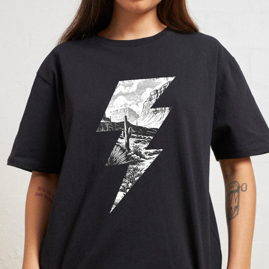 Person wearing a black t-shirt with a white graphic design on a plain background