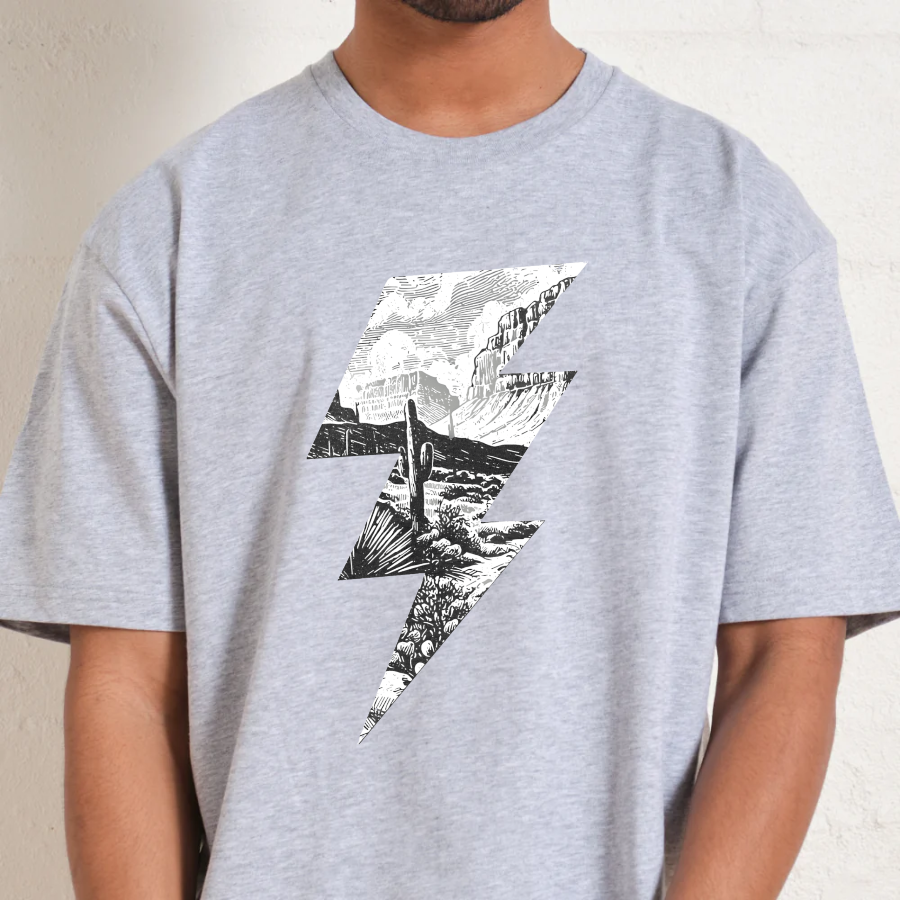 Person wearing a gray t-shirt with a black and white graphic design on a plain background