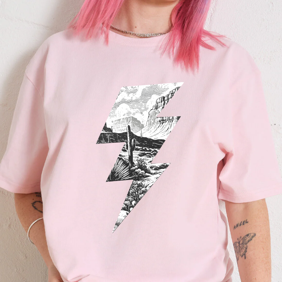 Person wearing a pink t-shirt with a black and white graphic design on a plain background