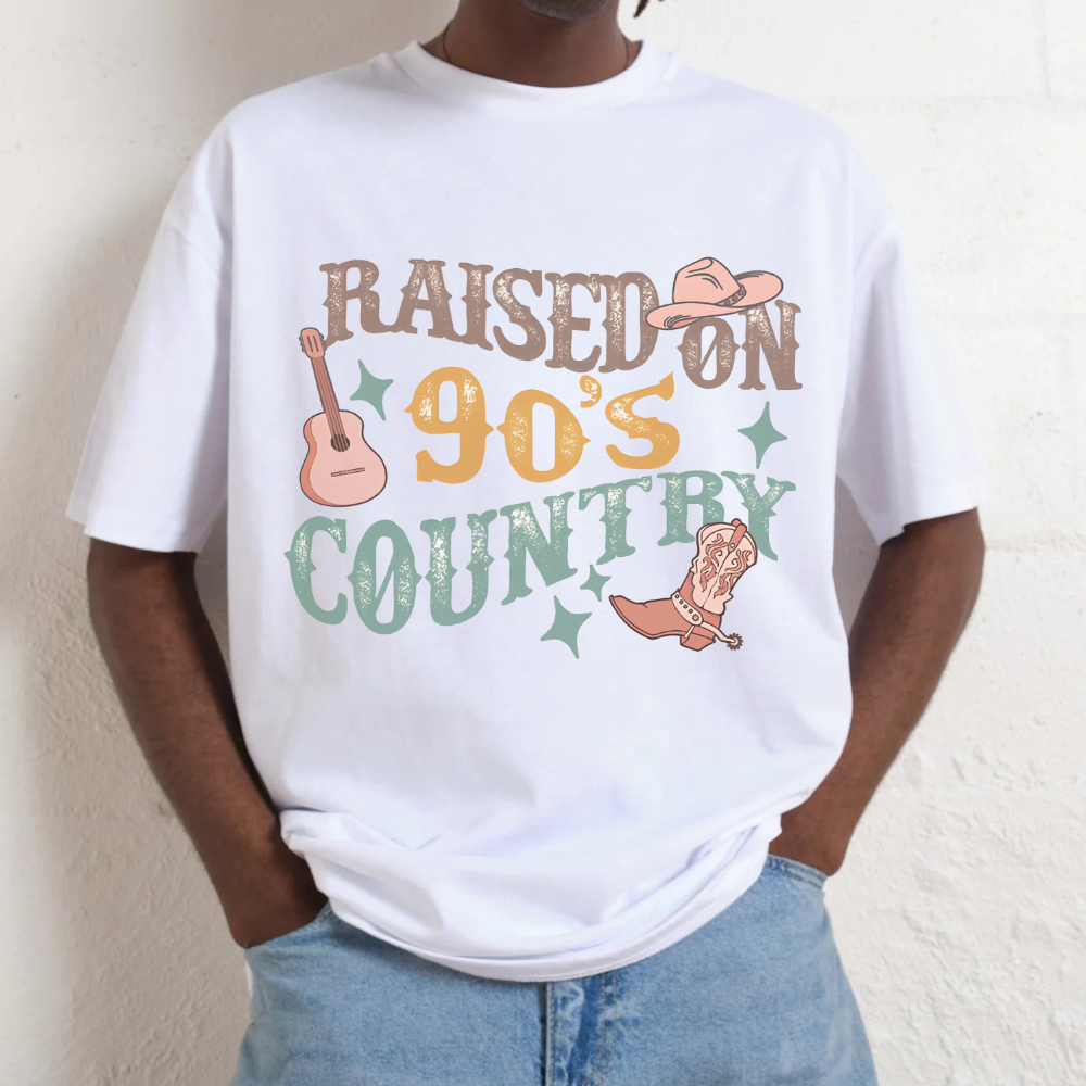 Person wearing a white t-shirt with 'Raised on 90's Country' graphic design.