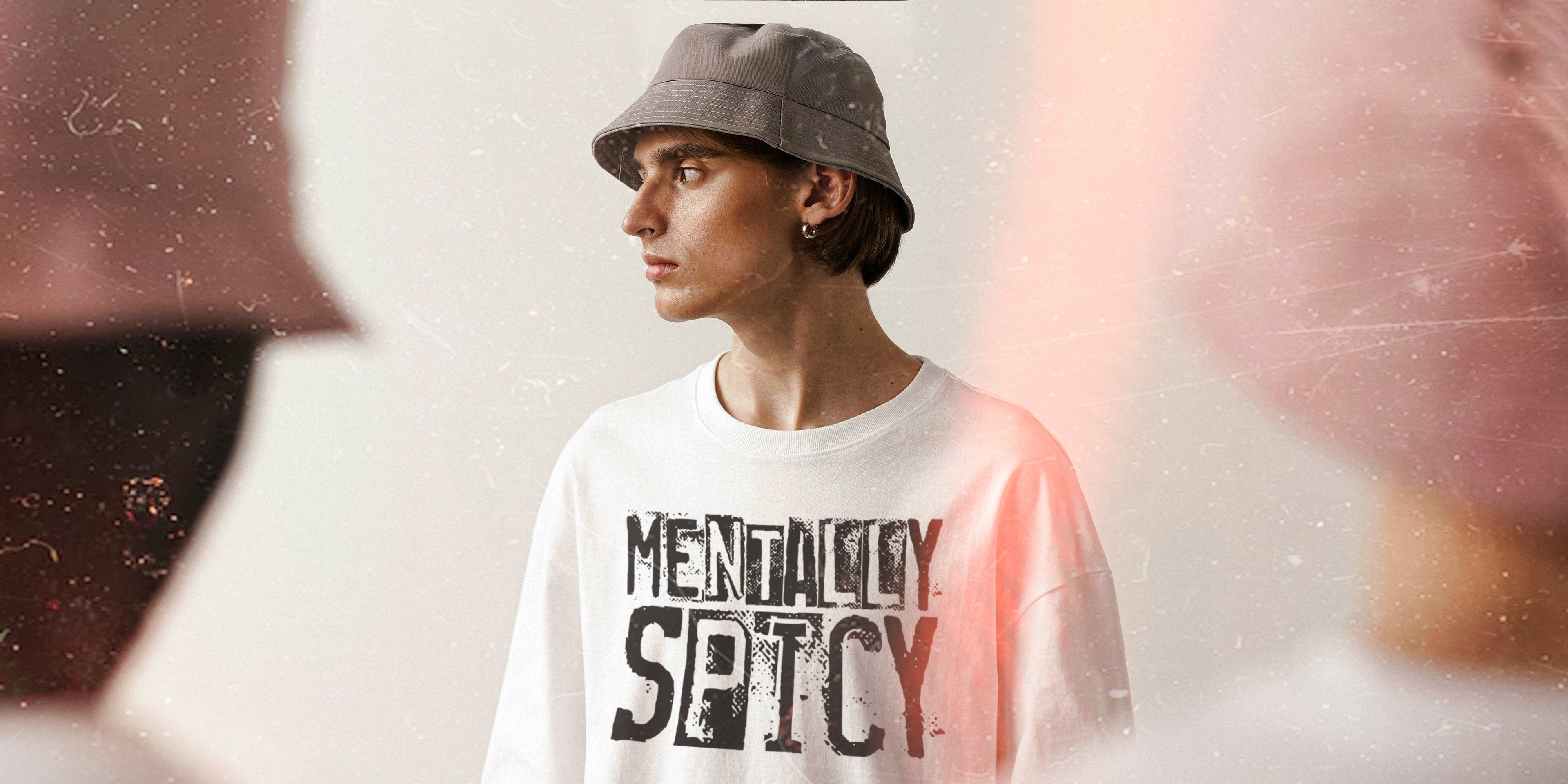 Person wearing a white t-shirt with 'MENTALLY SPICY' text, standing against a blurred background.