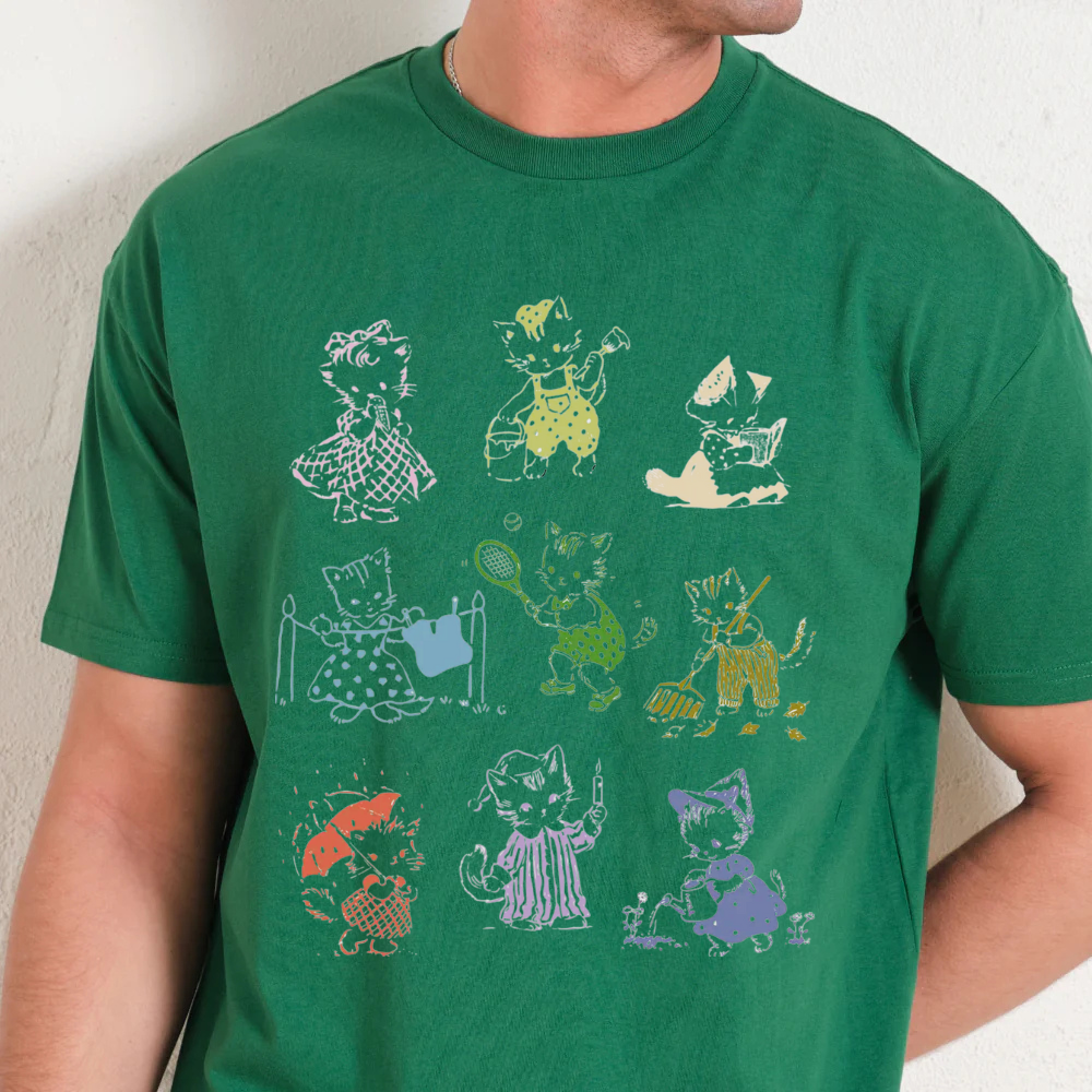 Green t-shirt with colorful cat illustrations on a plain background