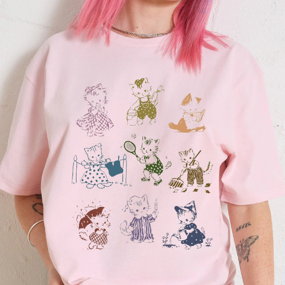 Vintage 90s cat graphic on oversized pink t-shirt, featuring playful illustrations and unisex design.