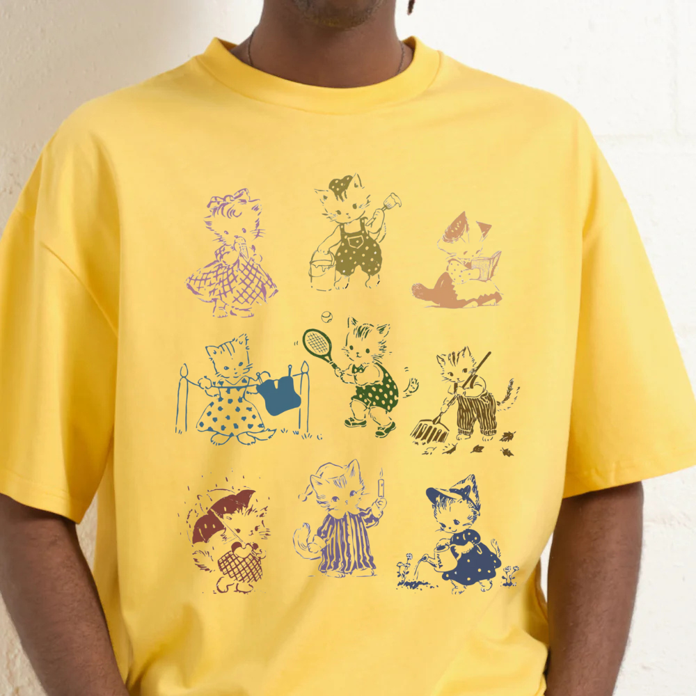 Person wearing a yellow t-shirt with cartoon cat illustrations
