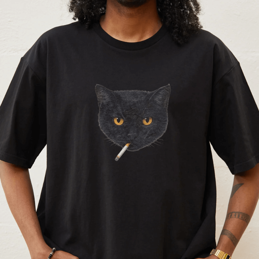 Person wearing a black t-shirt with a cat graphic smoking a cigarette.