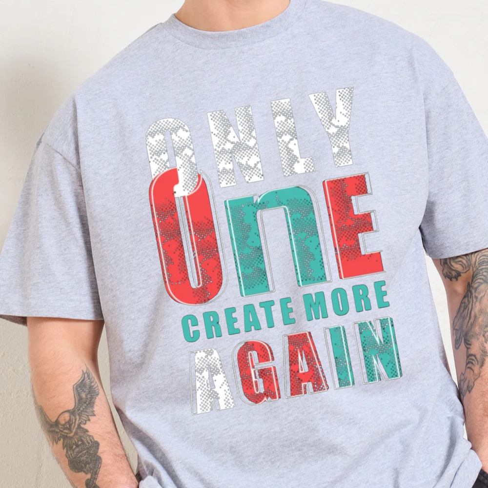 Model wearing a gray oversized t-shirt featuring the graphic 'ONLY ONE CREATE MORE AGAIN' in vibrant colors.