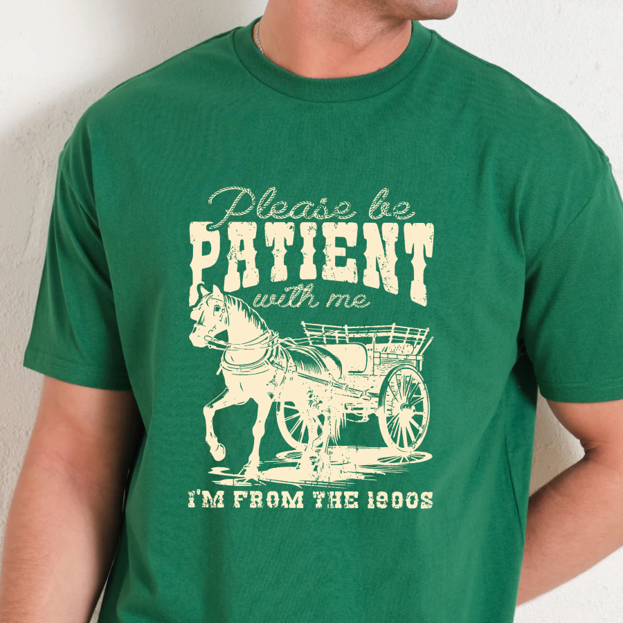 Green t-shirt with a horse and carriage graphic and text on a plain background