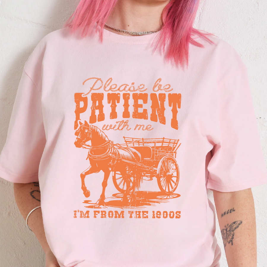 Person wearing a pink t-shirt with an orange graphic and text.