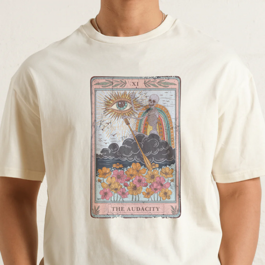 White t-shirt with a tarot card design featuring an eye, rainbow, and flowers on a plain background.
