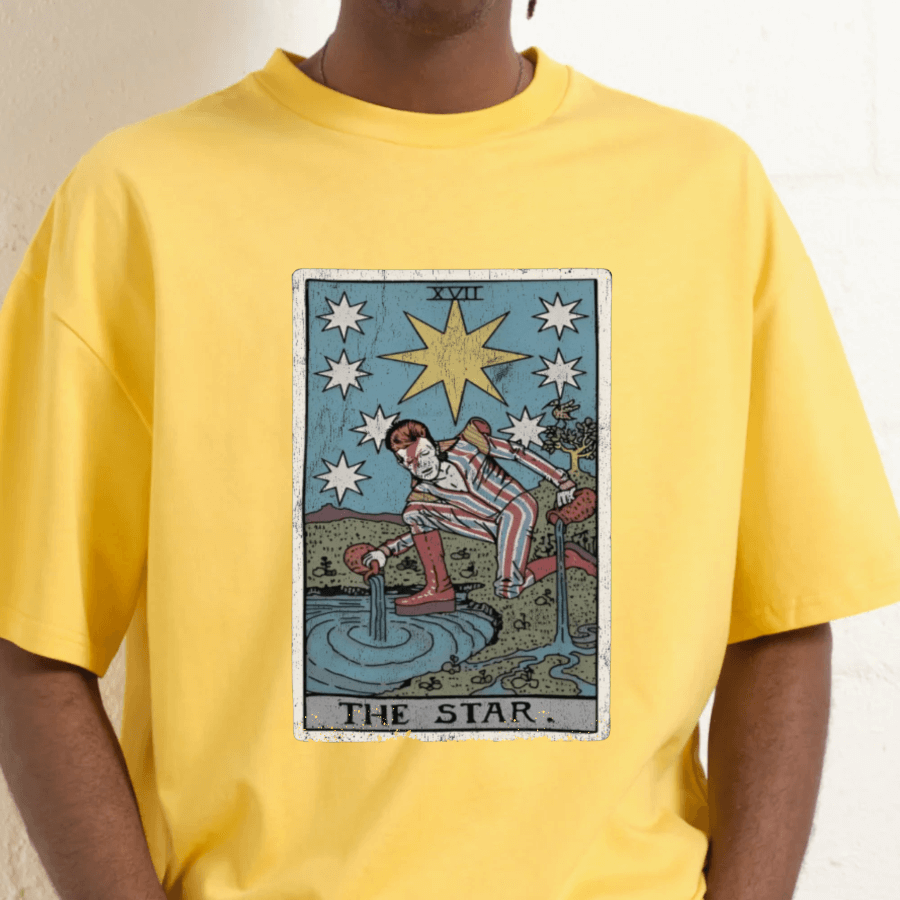 Person wearing a yellow t-shirt with 'The Star' tarot card design.