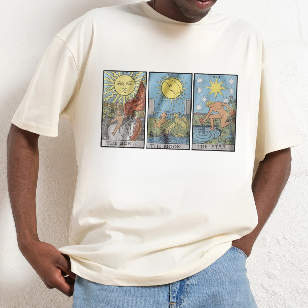Person wearing a white t-shirt with tarot card designs on a plain background