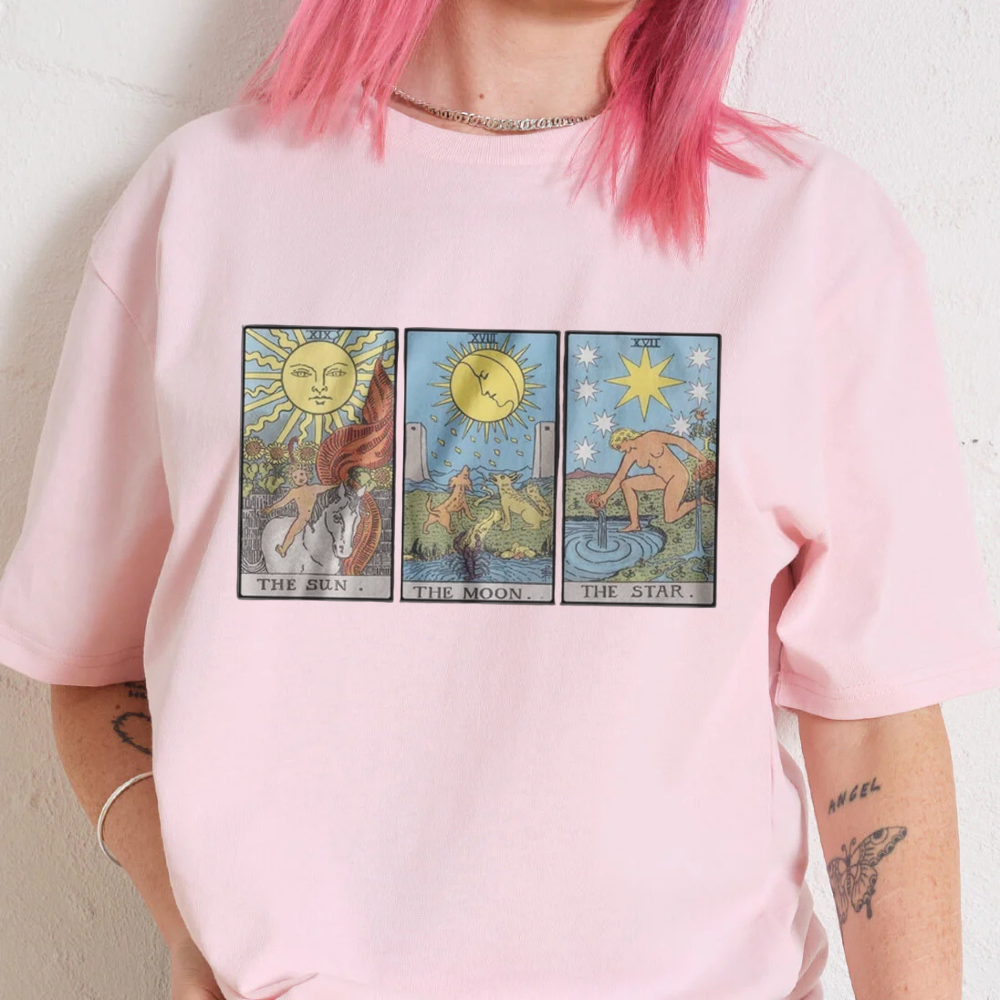 Person wearing a pink t-shirt with tarot card designs.