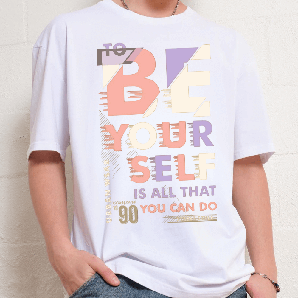 Unisex premium oversized T-shirt with 'To be yourself' slogan typography in pastel colors on 100% cotton.