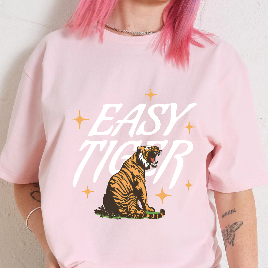 Person wearing a pink t-shirt with a tiger graphic and 'Easy Tiger' text.