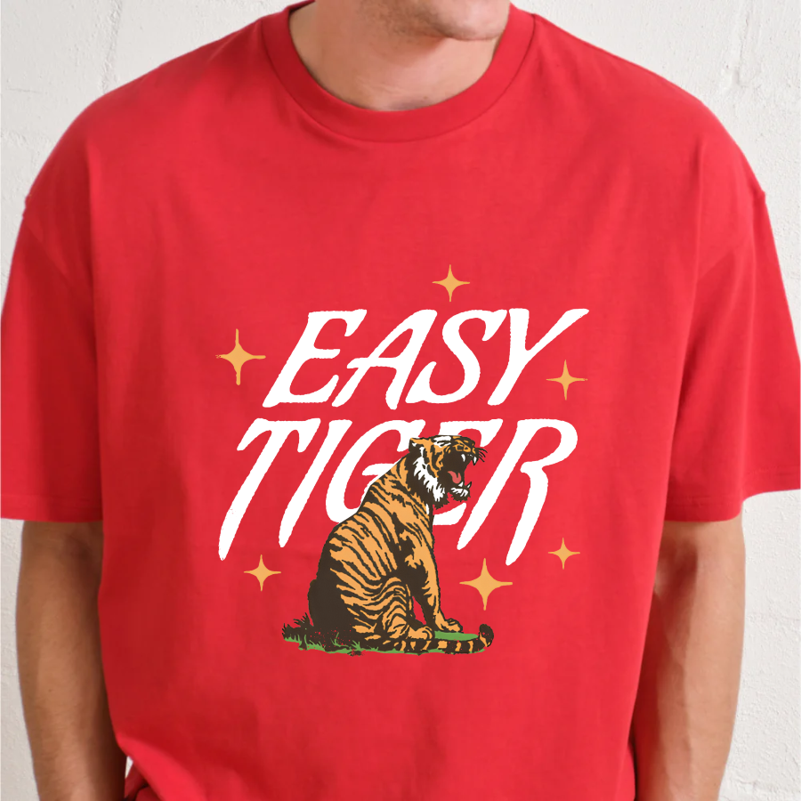 Red t-shirt with 'Easy Tiger' graphic design on a plain background