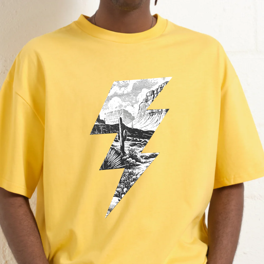 Yellow t-shirt with a black and white lightning bolt design on a neutral background