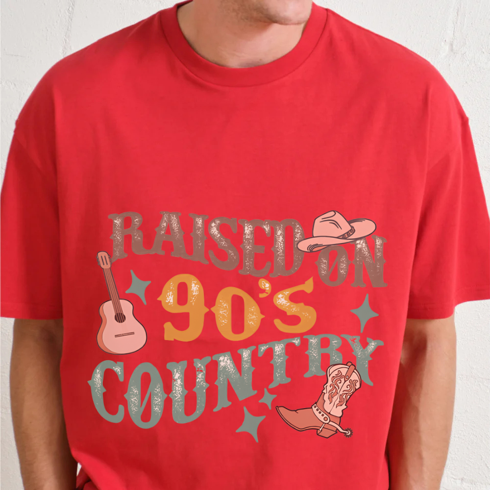 Red t-shirt with 'Raised on 90's Country' text and graphics on a plain background