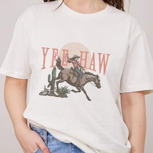 White t-shirt with a graphic of a cowboy on a horse and 'Yee Haw' text.