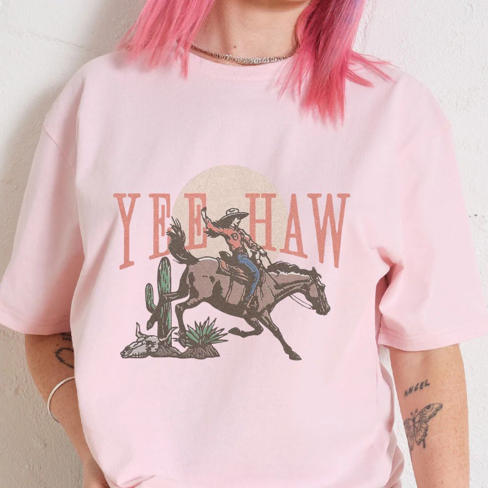 Person wearing a pink t-shirt with a cowboy graphic and 'Yee Haw' text.