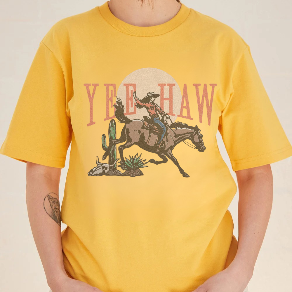 Yellow t-shirt with a graphic of a cowboy and 'Yee Haw' text on a plain background
